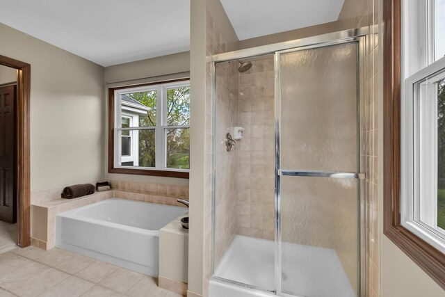bathroom featuring tile patterned floors, a stall shower, and a garden tub