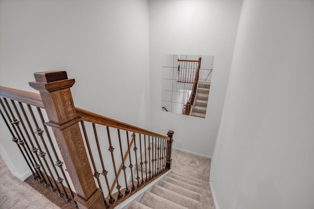 stairway featuring carpet flooring and baseboards