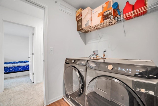 laundry room with baseboards, carpet flooring, visible vents, washer and clothes dryer, and laundry area