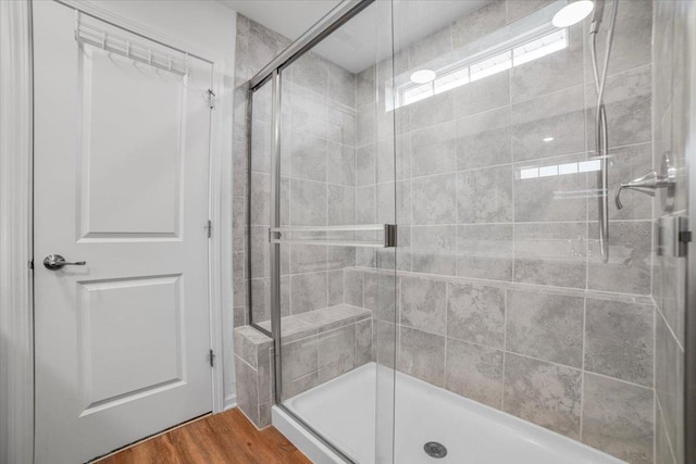 bathroom featuring a shower stall and wood finished floors