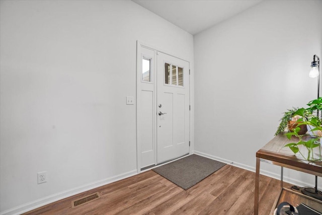 entrance foyer featuring visible vents, baseboards, and wood finished floors