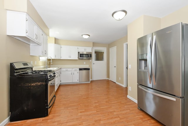 2644 Commercial Ave, South Chicago Heights, IL 60411 - kitchen featuring light wood-style flooring, white cabinets, appliances with stainless steel finishes, a sink, and light countertops