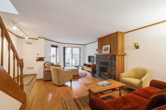 801 S Plymouth Ct Unit P, Chicago, IL 60605 - living area featuring light wood-type flooring, track lighting, a tiled fireplace, stairway, and crown molding