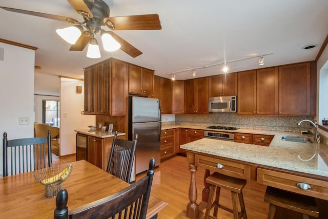 801 S Plymouth Ct Unit P, Chicago, IL 60605 - kitchen featuring a peninsula, light wood-style floors, decorative backsplash, stainless steel appliances, and a sink