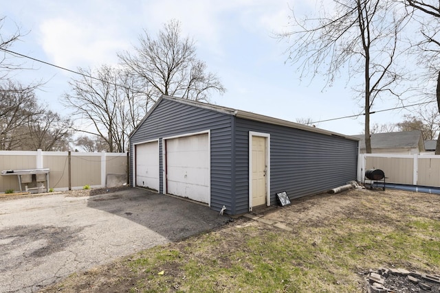 detached garage featuring fence