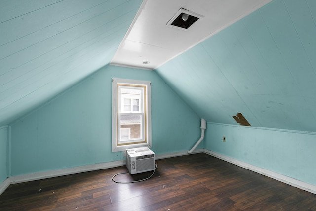 additional living space featuring a wall mounted air conditioner, lofted ceiling, baseboards, and wood finished floors