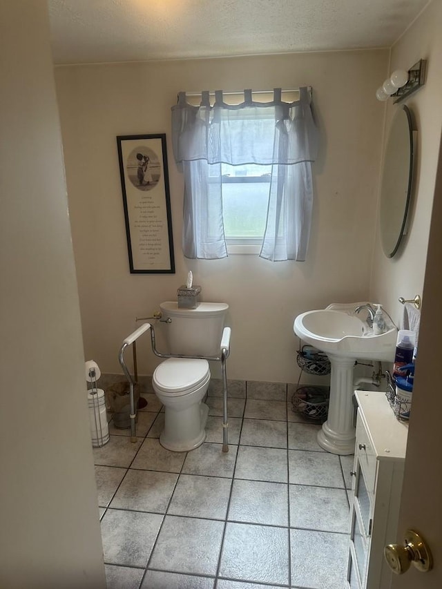 bathroom with tile patterned flooring, a sink, and toilet