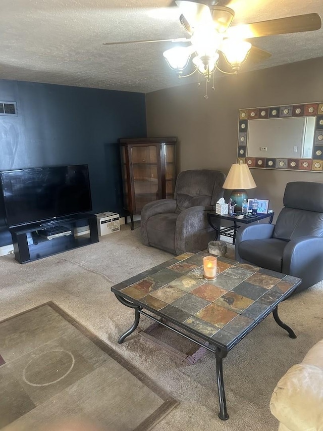 carpeted living room with a textured ceiling, a ceiling fan, and visible vents