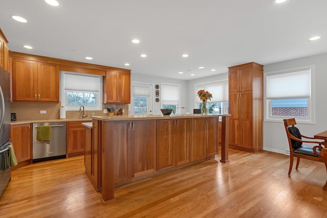 kitchen featuring light countertops, a sink, light wood-type flooring, and stainless steel appliances
