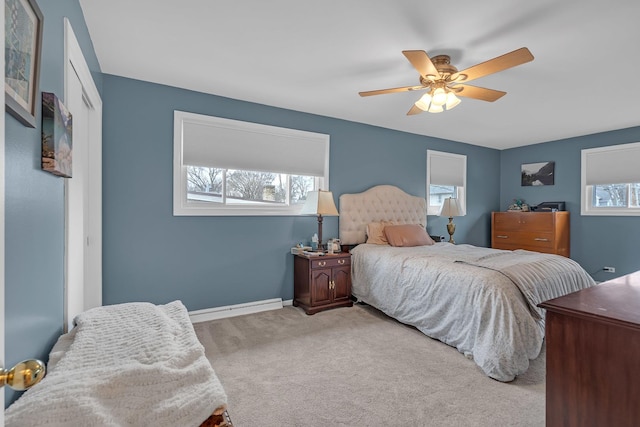 carpeted bedroom featuring baseboards, ceiling fan, and a baseboard heating unit