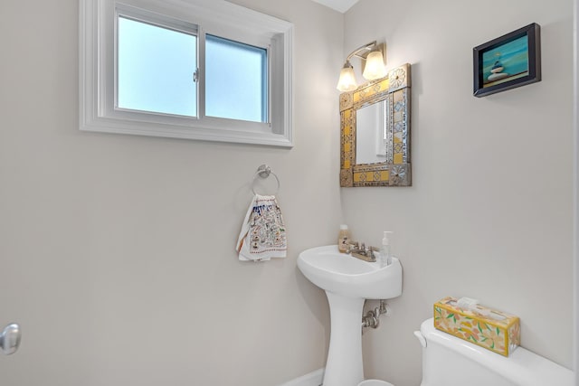 bathroom with toilet and baseboards