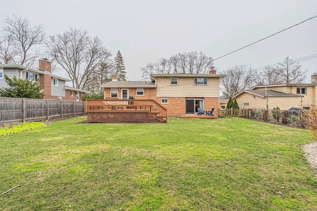 back of house featuring a fenced backyard, a yard, a deck, and brick siding