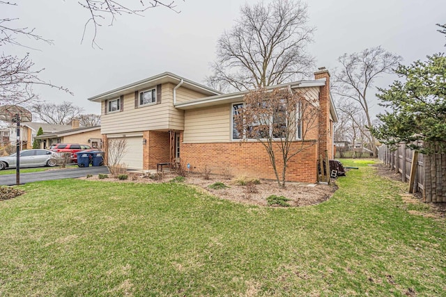tri-level home with fence, a chimney, brick siding, an attached garage, and driveway