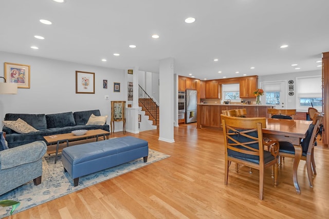 living area featuring recessed lighting, light wood-style flooring, and stairs