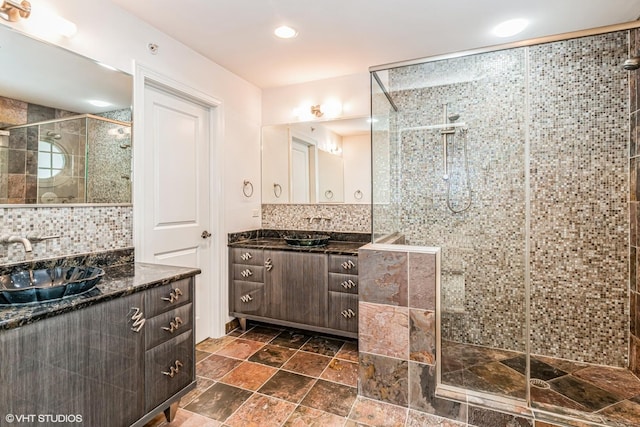 bathroom with recessed lighting, vanity, stone finish flooring, tasteful backsplash, and a stall shower