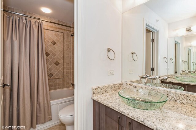 full bath featuring shower / bath combination with curtain, toilet, and vanity