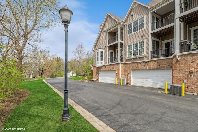exterior space featuring a garage, driveway, and central AC