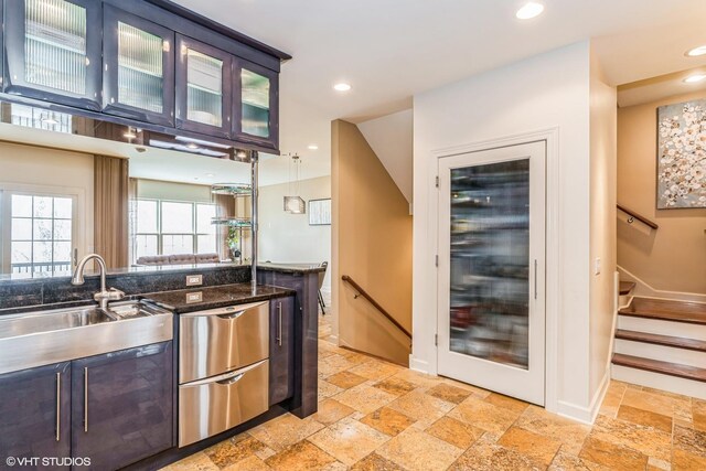 bar featuring stone tile floors, a sink, and recessed lighting