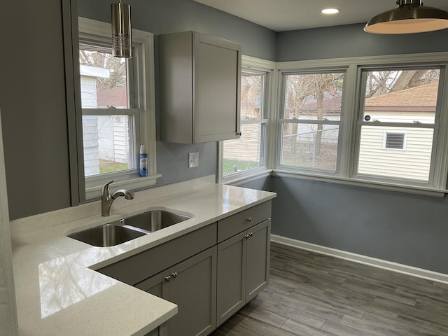 451 Clyde Ave, Calumet City, IL 60409 - kitchen featuring gray cabinets, wood finished floors, light countertops, a sink, and baseboards