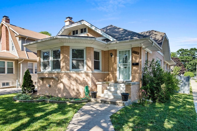 701 N 4th Ave, Maywood, IL 60153 - bungalow-style house with a shingled roof, brick siding, a chimney, and a front lawn
