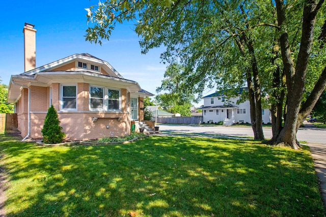 701 N 4th Ave, Maywood, IL 60153 - view of front facade featuring a front yard, brick siding, fence, and a chimney
