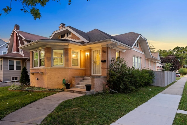 701 N 4th Ave, Maywood, IL 60153 - bungalow-style home with roof with shingles, a yard, fence, and brick siding