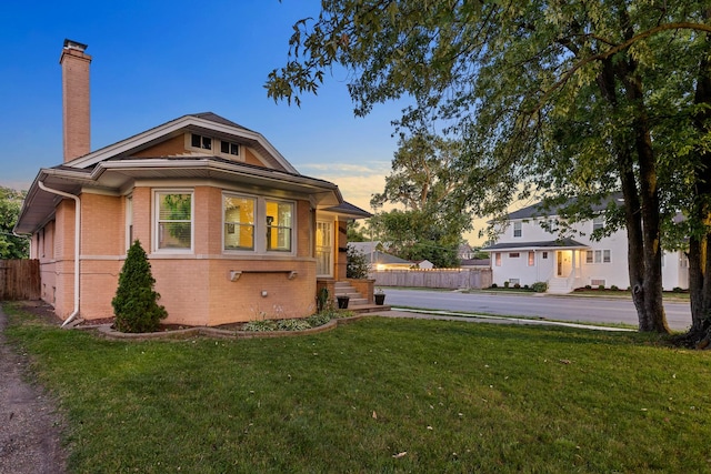 701 N 4th Ave, Maywood, IL 60153 - exterior space featuring a chimney, a yard, fence, and brick siding