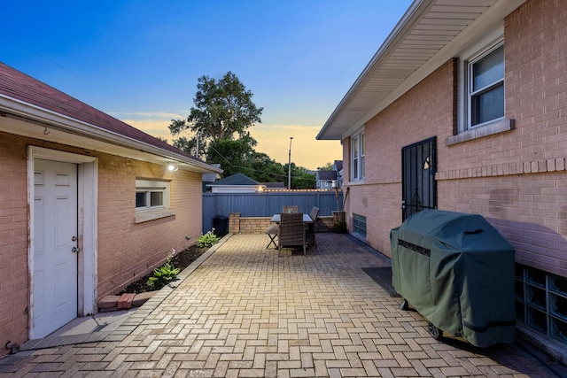 701 N 4th Ave, Maywood, IL 60153 - patio terrace at dusk featuring outdoor dining space, a grill, and fence