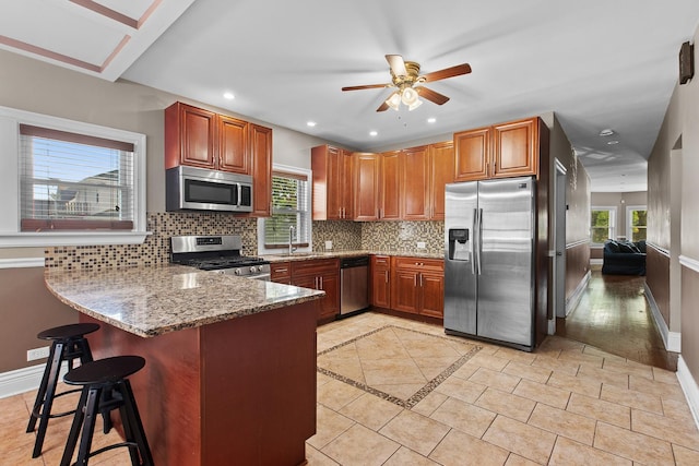 701 N 4th Ave, Maywood, IL 60153 - kitchen featuring baseboards, backsplash, light stone counters, and appliances with stainless steel finishes