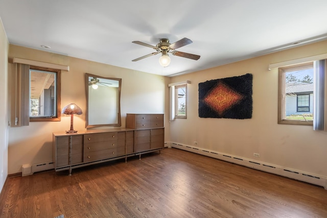 bedroom featuring a baseboard radiator, multiple windows, and dark wood-style floors
