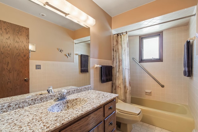 full bathroom with tile walls, shower / bath combo with shower curtain, vanity, and a wainscoted wall
