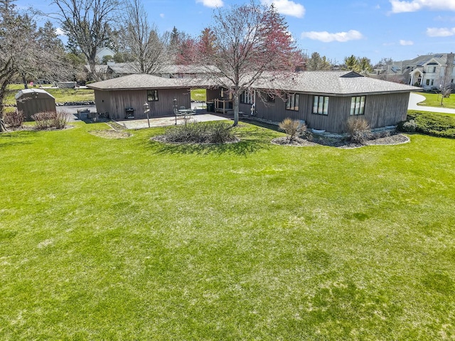 rear view of house with a patio and a yard