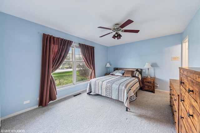 carpeted bedroom featuring visible vents, baseboards, and ceiling fan