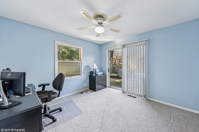 carpeted home office with baseboards, a ceiling fan, and visible vents