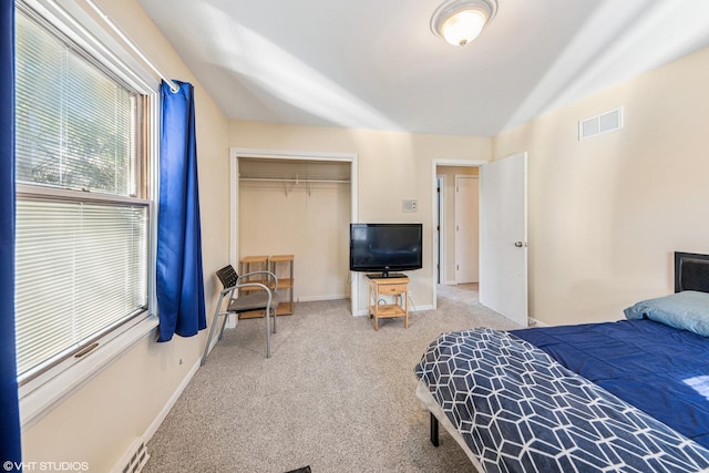 bedroom featuring visible vents, baseboards, carpet flooring, and a closet