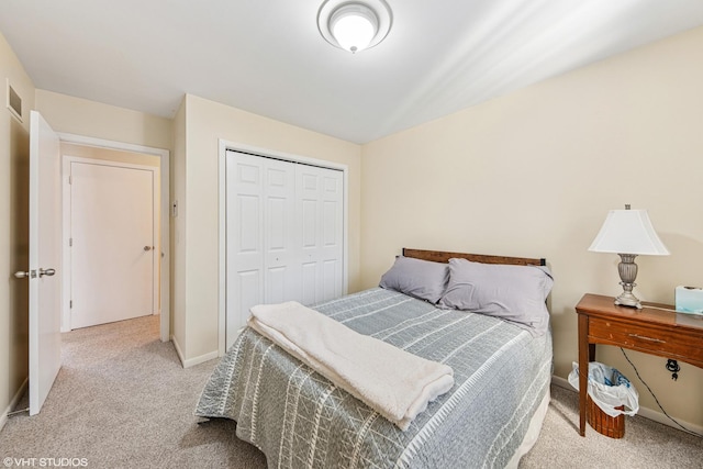 bedroom featuring light carpet, a closet, and baseboards
