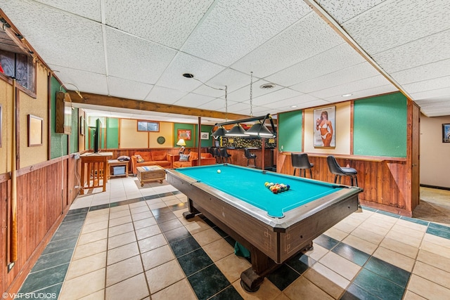 rec room with wood walls, pool table, wainscoting, and a drop ceiling