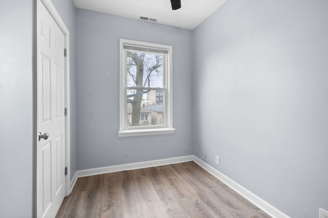 unfurnished bedroom with wood finished floors, ceiling fan, baseboards, and visible vents