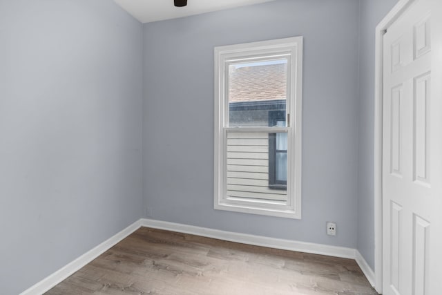 empty room with baseboards, a ceiling fan, and wood finished floors