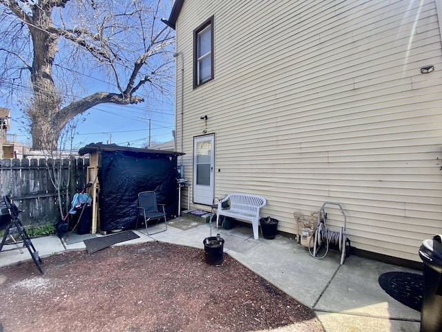 view of side of home with a patio area and fence
