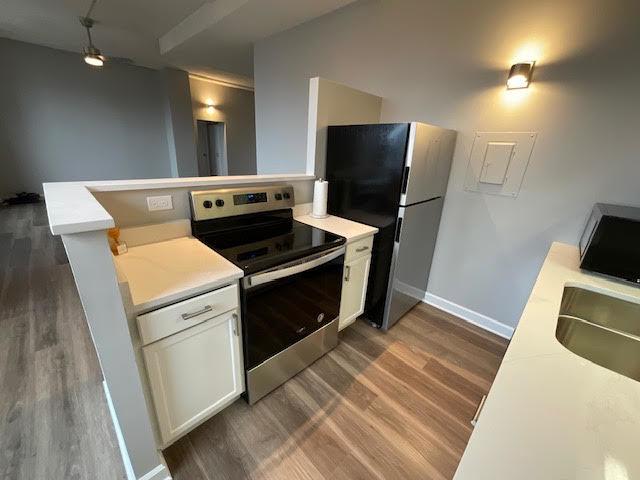 600 S Dearborn St Unit 1603, Chicago, IL 60605 - kitchen featuring stainless steel appliances, dark wood-style floors, light countertops, and white cabinets