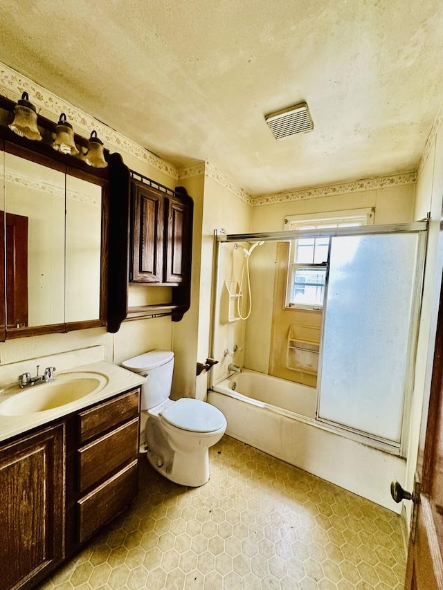 full bathroom featuring shower / bath combination with glass door, vanity, tile patterned floors, toilet, and visible vents