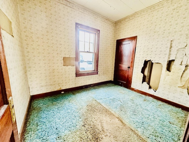 unfurnished room with wallpapered walls and baseboards
