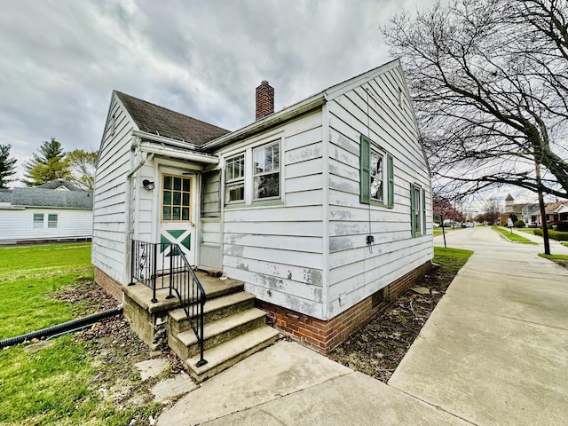 exterior space featuring crawl space, a chimney, fence, and a lawn