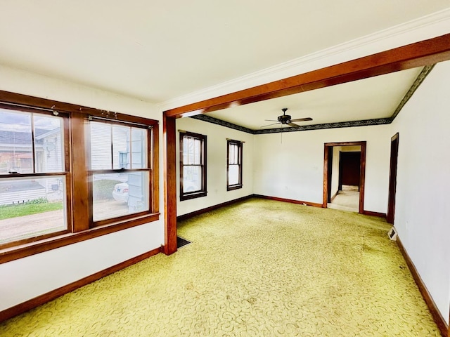 spare room with baseboards, light colored carpet, crown molding, and ceiling fan
