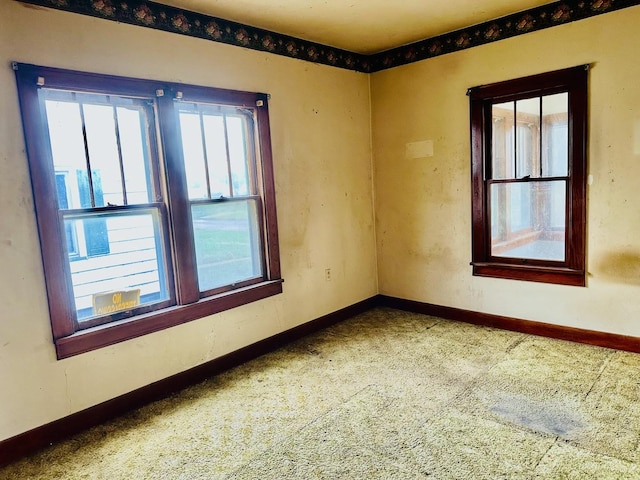 spare room with baseboards and carpet floors