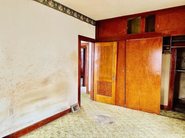 unfurnished bedroom with visible vents, baseboards, carpet flooring, and a closet