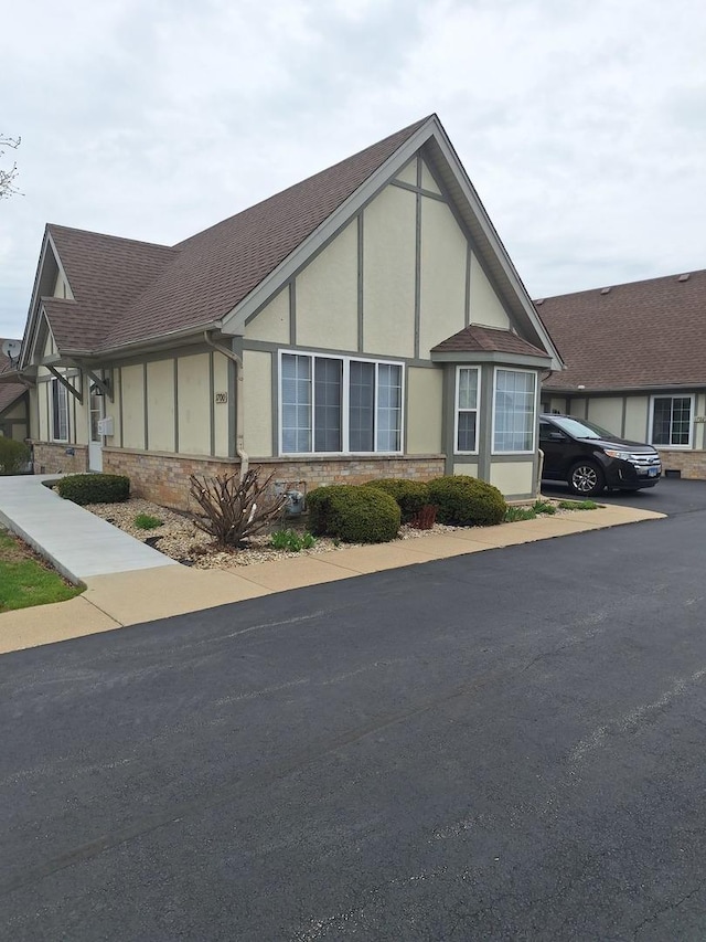 view of front of property with roof with shingles and stucco siding