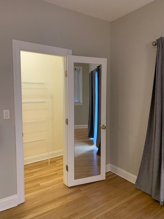 empty room with baseboards and light wood-style flooring