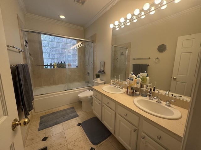 full bath with double vanity, toilet, ornamental molding, and a sink